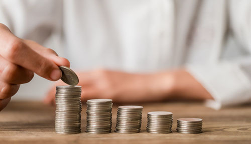 Midsection of man holding coins on table