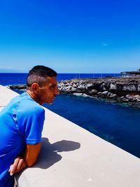 Man on beach against clear blue sky