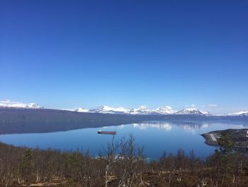 Scenic view of lake and mountains against clear sky