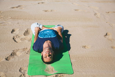 High angle view of man doing yoga on beach