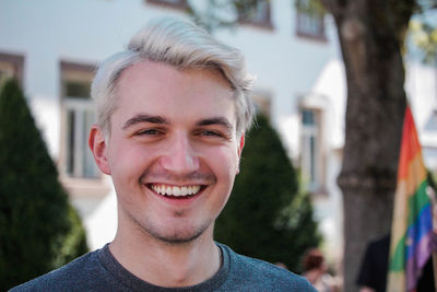 Portrait of smiling young man against trees