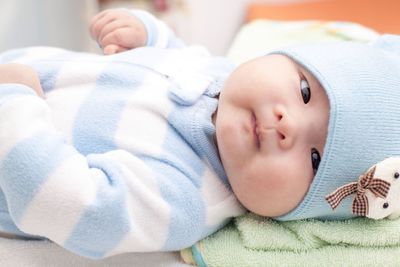 Close-up portrait of cute baby boy lying on bed