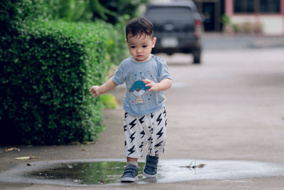 Portrait a 2-year-old asian boy trampling on the water.