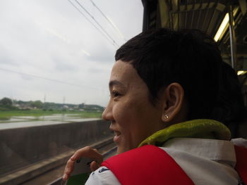 Smiling woman looking through window of train