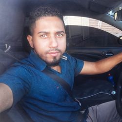 Portrait of young man sitting in car