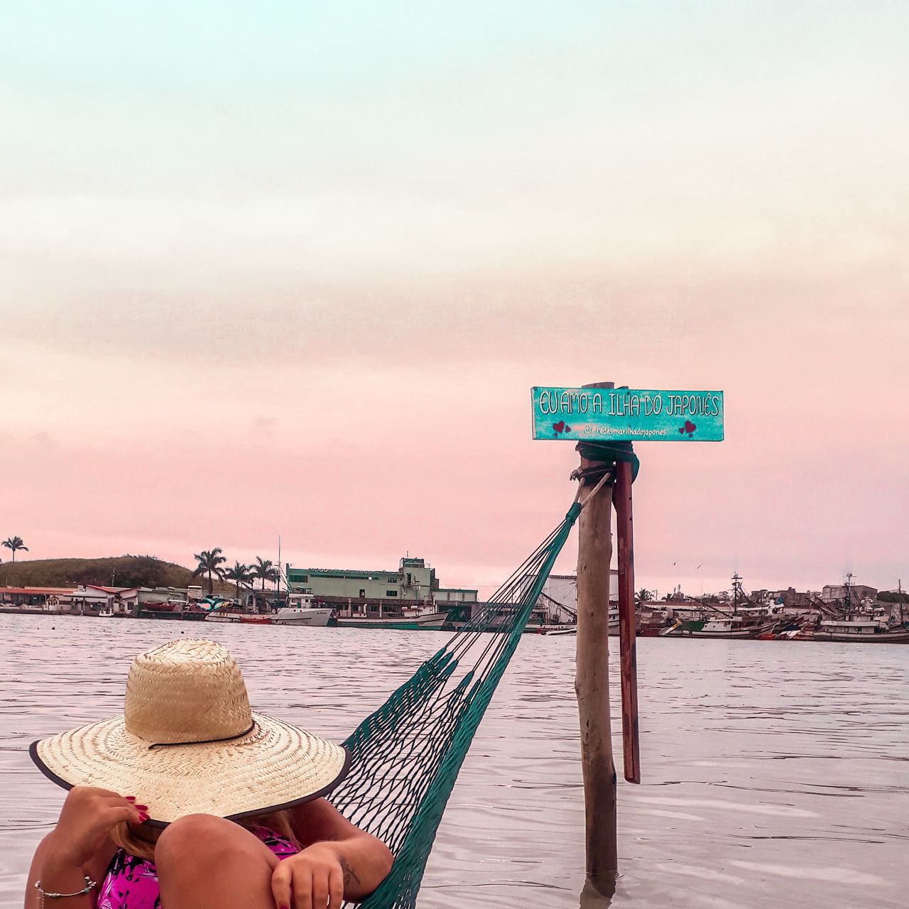 WOMAN HOLDING UMBRELLA BY SEA AGAINST SKY