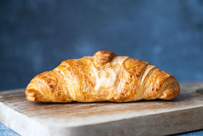 Fresh and juicy croissant on a cutting board on a dark background. place for text. fresh bakery