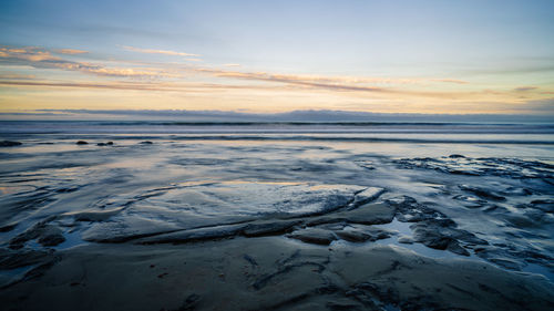 Scenic view of frozen sea against sky during sunset