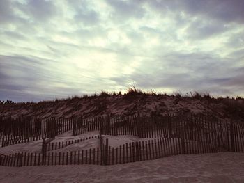 Scenic view of field against cloudy sky