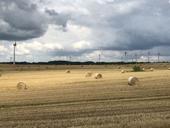 Hay bales on field against sky