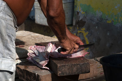 Midsection of fishmonger is working