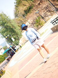 Man standing with umbrella on sunny day