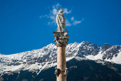 Low angle view of statue against blue sky