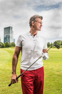 Man holding umbrella against sky