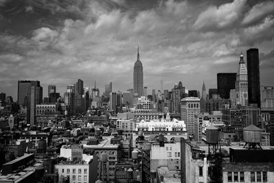 View of cityscape against cloudy sky