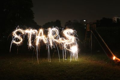 Firework display on field at night