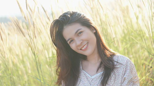 Portrait of smiling young woman lying on field