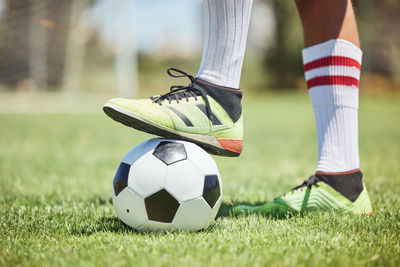 Low section of man playing soccer at park