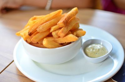 French fries in bowl with ketchup on table