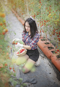 Full length of woman sitting on plant