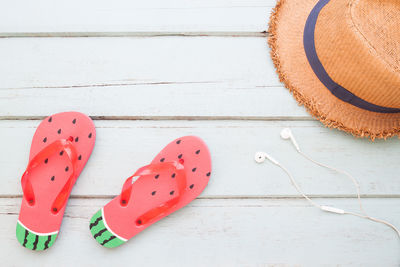 Directly above shot of flip flops and sun hat on table