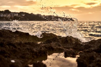 Sea waves splashing on shore during sunset