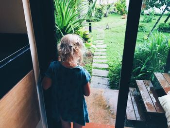 Rear view of young girl standing in doorway