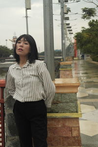 Young woman looking down while standing outdoors