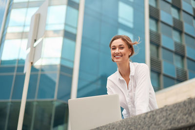 Low angle view of woman using mobile phone