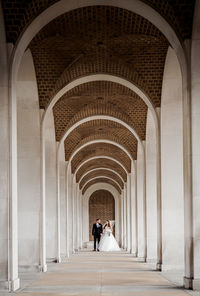 Rear view of people walking in corridor of building