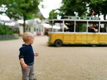 Boy looking away while standing outdoors