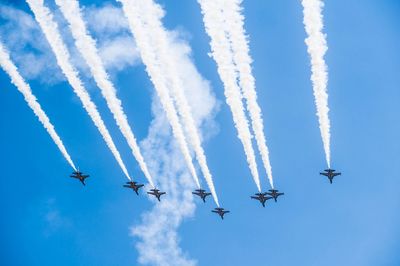 Low angle view of airshow against sky