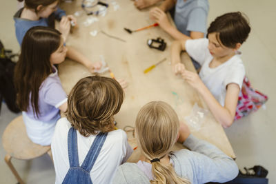 High angle view of male and female students working on robotics project at school