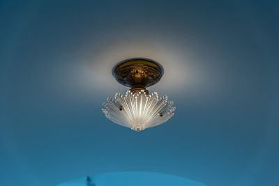 Close-up of illuminated lamp against blue background
