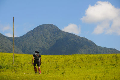 Full length of man with horse on field against sky