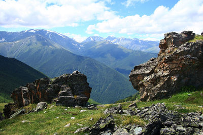 Alpine pass with rocks and a distant view of the mountain ranges in altai in summer