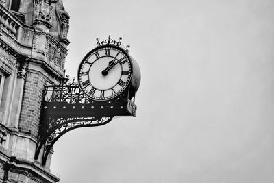 Low angle view of clock against sky