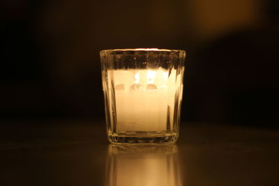 Close-up of wine glass on table against black background