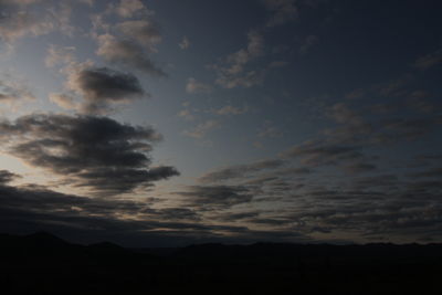 Low angle view of silhouette mountain against dramatic sky