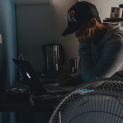 Man using mobile phone while sitting on table at home