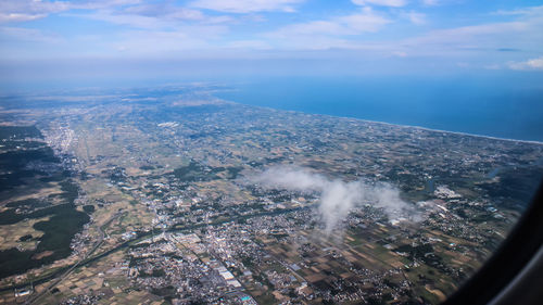 Aerial view of sea and cityscape against sky