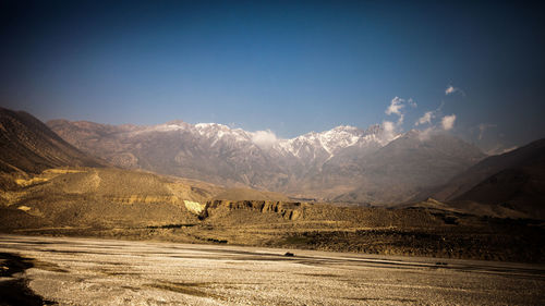 Scenic view of snowcapped mountains against blue sky