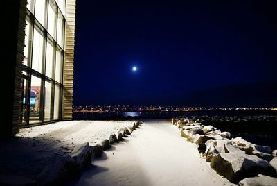 Illuminated buildings against sky at night