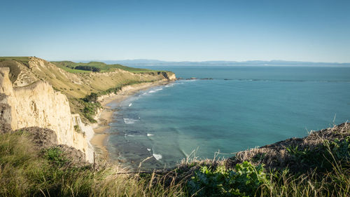 View on a rugged coast with cliffs and turquoise ocean waters, cape kidnappers, north, new zealand