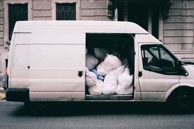 Sacks in van on street against building