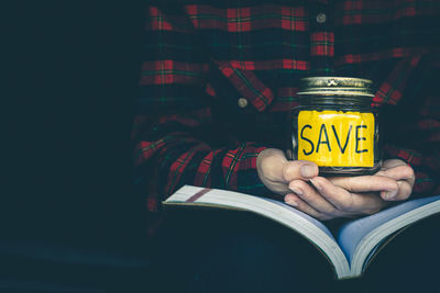 Midsection of man holding book