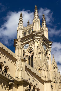 Low angle view of bell tower against cloudy sky