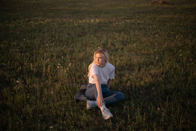 Full length of a young man sitting on field