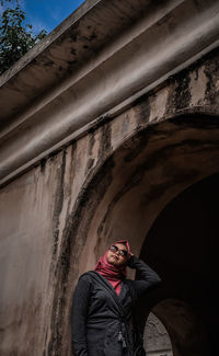 Low section of woman standing against wall