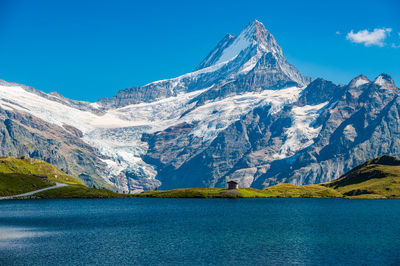 Scenic view of snowcapped mountains against blue sky